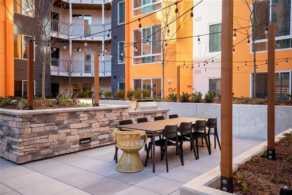 A patio with a table and chairs is in front of a building.