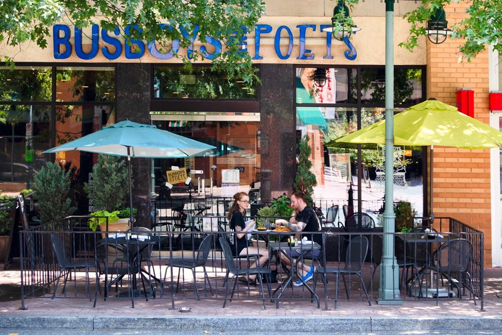 A restaurant named Busboys and Poets with people sitting at tables outside.