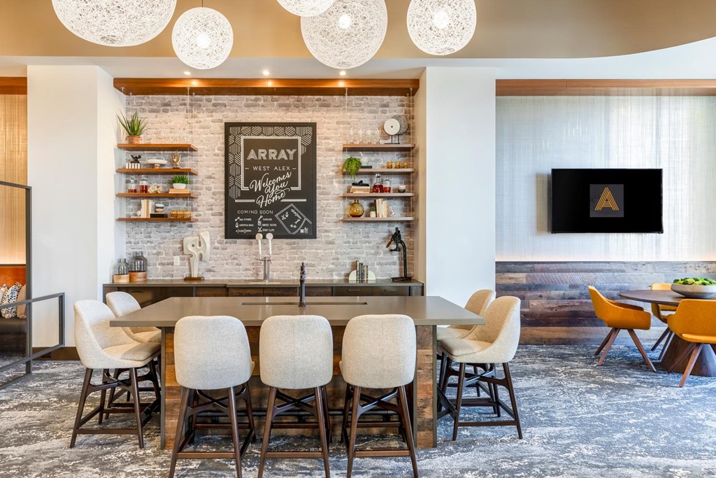 A kitchen with a bar and chairs.