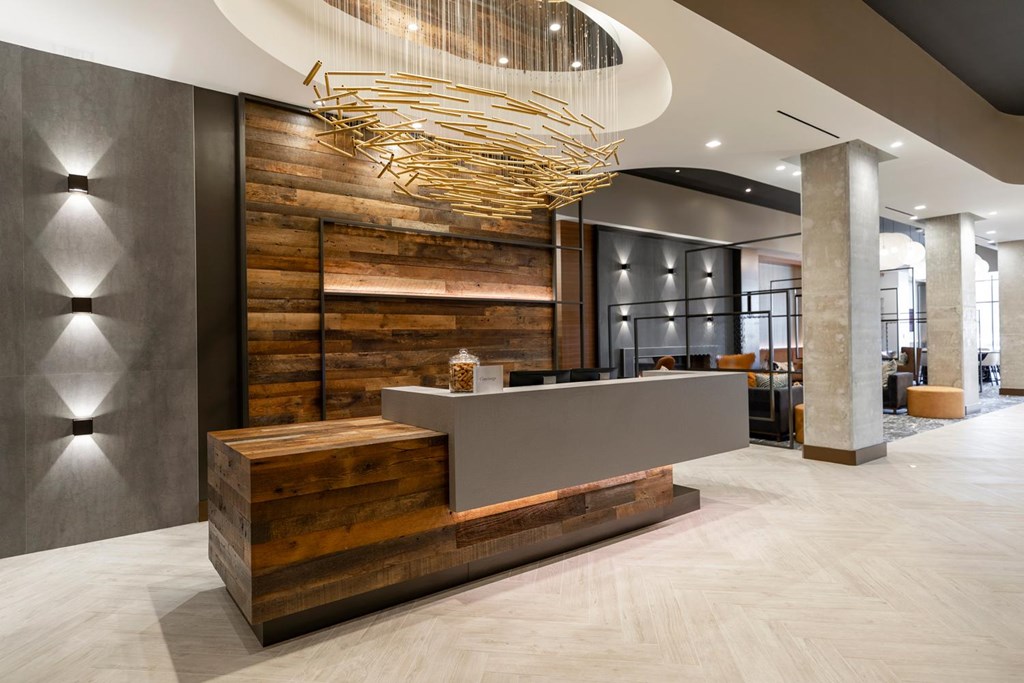 A reception area with a wooden counter and a hanging light fixture.