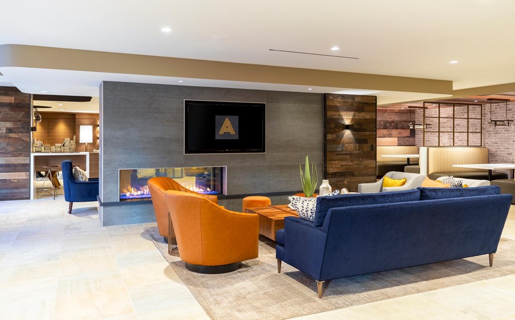 A modern living room with a fireplace and a blue couch.