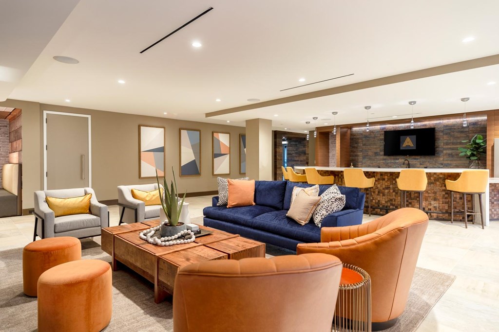 A living room with a blue couch and orange chairs.