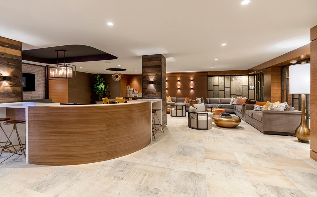 A modern living room with a curved wooden reception desk.