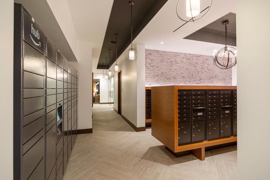 A hallway with a brick wall and a wooden cabinet with drawers.