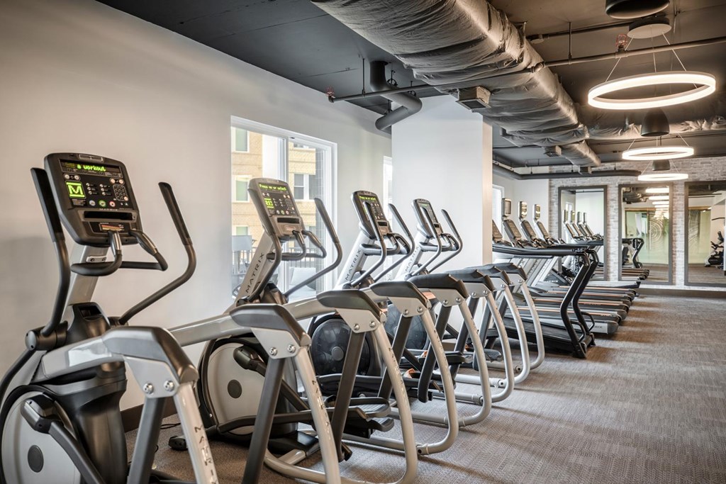 A gym with treadmills and a carpeted floor.