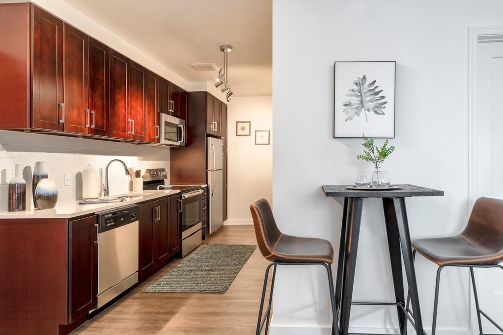 A kitchen with brown cabinets and a black table.