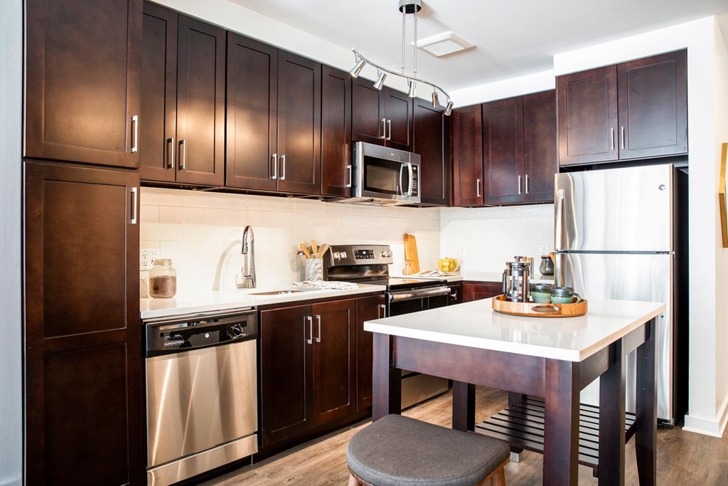 A kitchen with dark wood cabinets and stainless steel appliances.