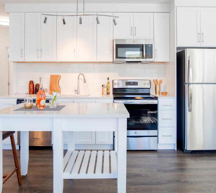 A white kitchen with a table and a fridge.