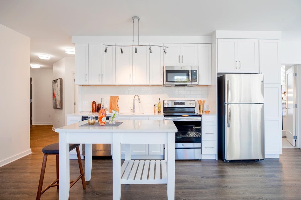 A white kitchen with a table and chairs.