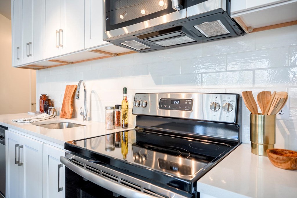 A modern kitchen with a stove top oven and a microwave above it.