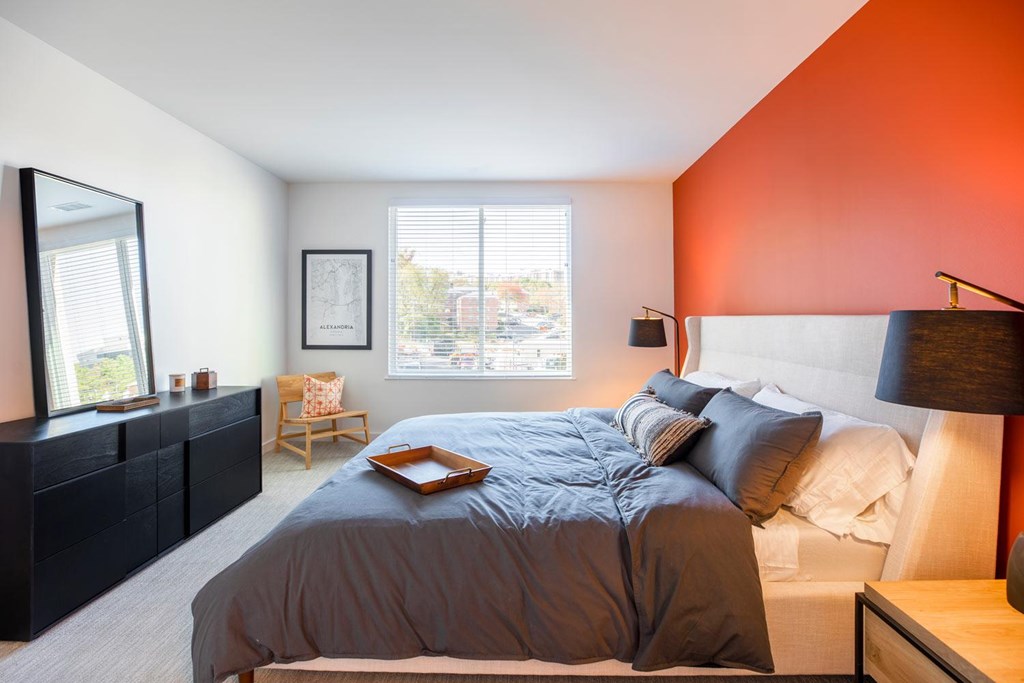 A bedroom with a large bed and a wooden nightstand.