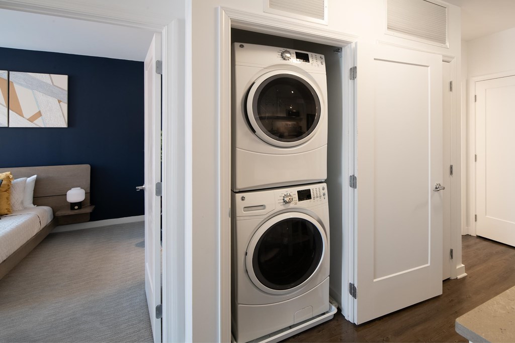 A modern washing machine is built into a wall in a room.
