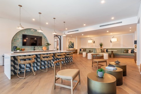 A modern living room with a bar area and a television.at Corban Freedom Apartments, Orlando, FL 32837