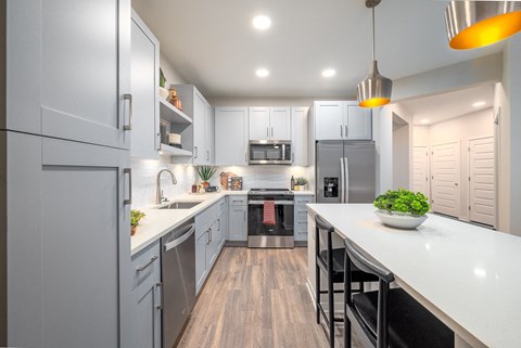 A modern kitchen with a large island and stainless steel appliances.at Corban Freedom Apartments, Orlando, 32837
