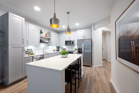A modern kitchen with white cabinets and a large island.at Corban Freedom Apartments, Orlando, FL