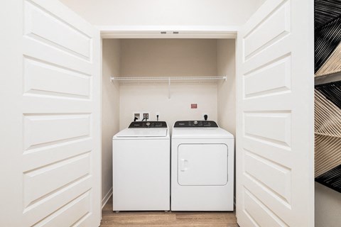 Model laundry closet at Corban Freedom Apartments in Orlando, FL, featuring in unit washer and dryer.