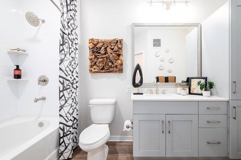 A white bathroom with a toilet, sink, and shower.at Corban Freedom Apartments, Orlando Florida