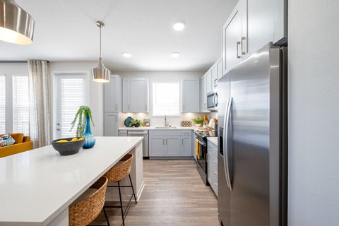 A modern kitchen with a large island and stainless steel appliances.at Corban Freedom Apartments, Orlando Florida