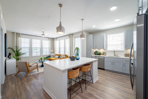 A kitchen with a white island and wooden floors.at Corban Freedom Apartments, Orlando