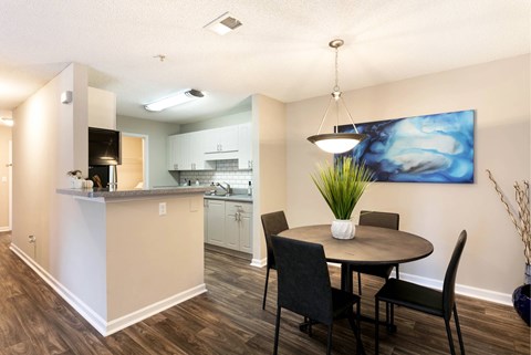 A kitchen with a dining table and chairs.
