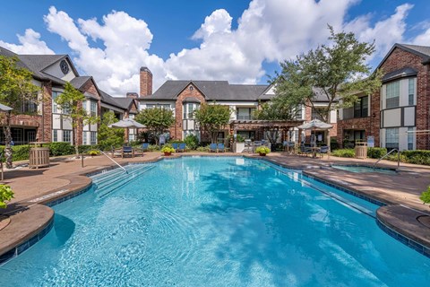 Large outdoor pool surrounded by trees at Joule on Memorial apartments in Harris County, TX.