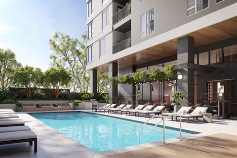 A modern building with a pool and lounge chairs.