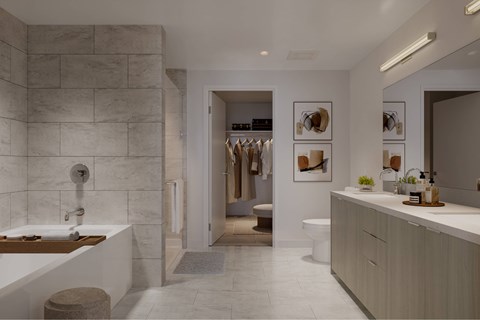 A bathroom with a marble wall and a white bathtub.