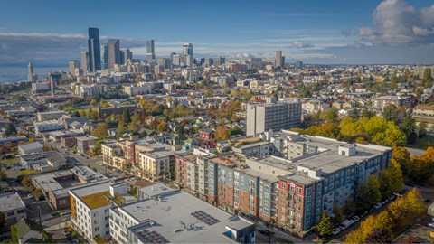 A cityscape with buildings of various heights and colors, with a clear sky above.