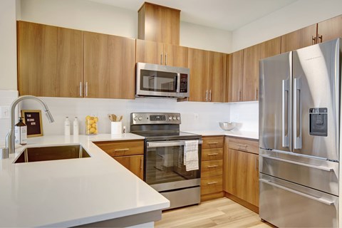 A modern kitchen with wooden cabinets and stainless steel appliances.