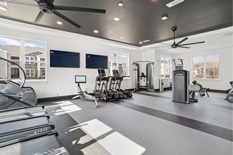 A spacious gym with a variety of equipment including treadmills, elliptical machines, and a rowing machine.