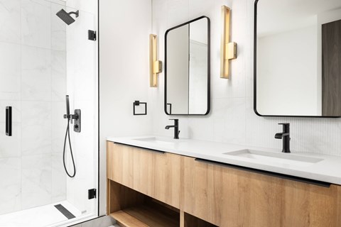 A modern bathroom with a white countertop and a wooden vanity.