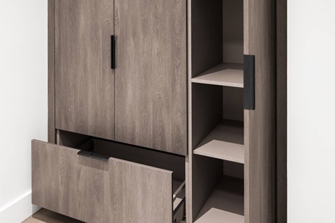 A wooden cabinet with a black handle and two shelves.