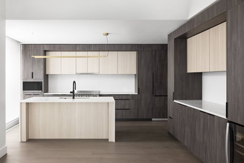 A modern kitchen with a large island and wooden cabinets.