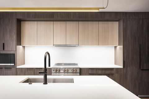 A modern kitchen with a stainless steel sink and a stove top.
