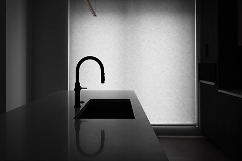 A black and white image of a kitchen sink with a faucet.