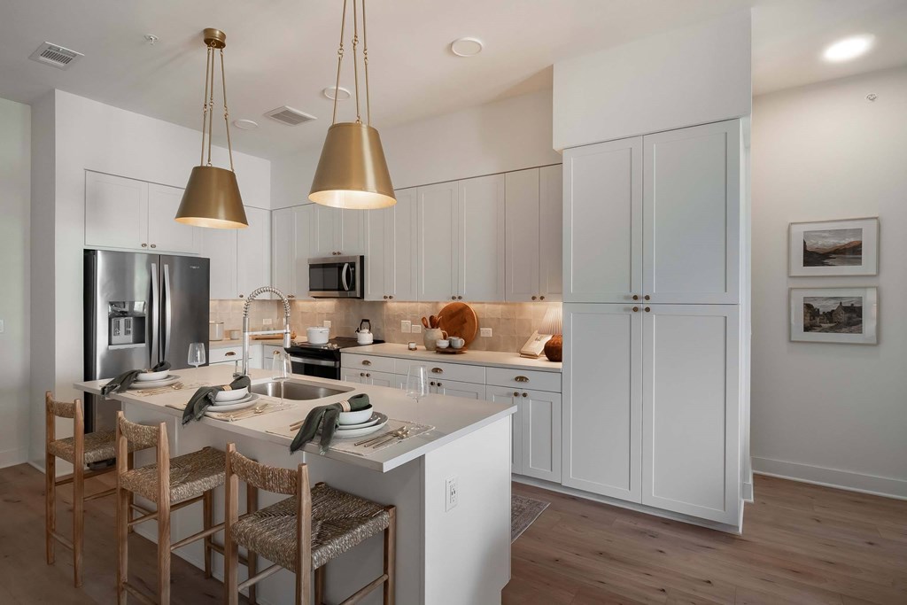 A modern kitchen with white cabinets and a center island.