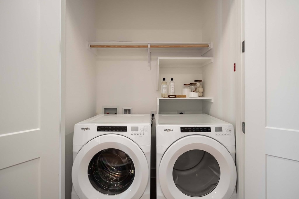 A white laundry room with two washing machines.