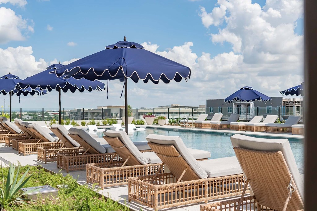A row of sun loungers are arranged on a patio.