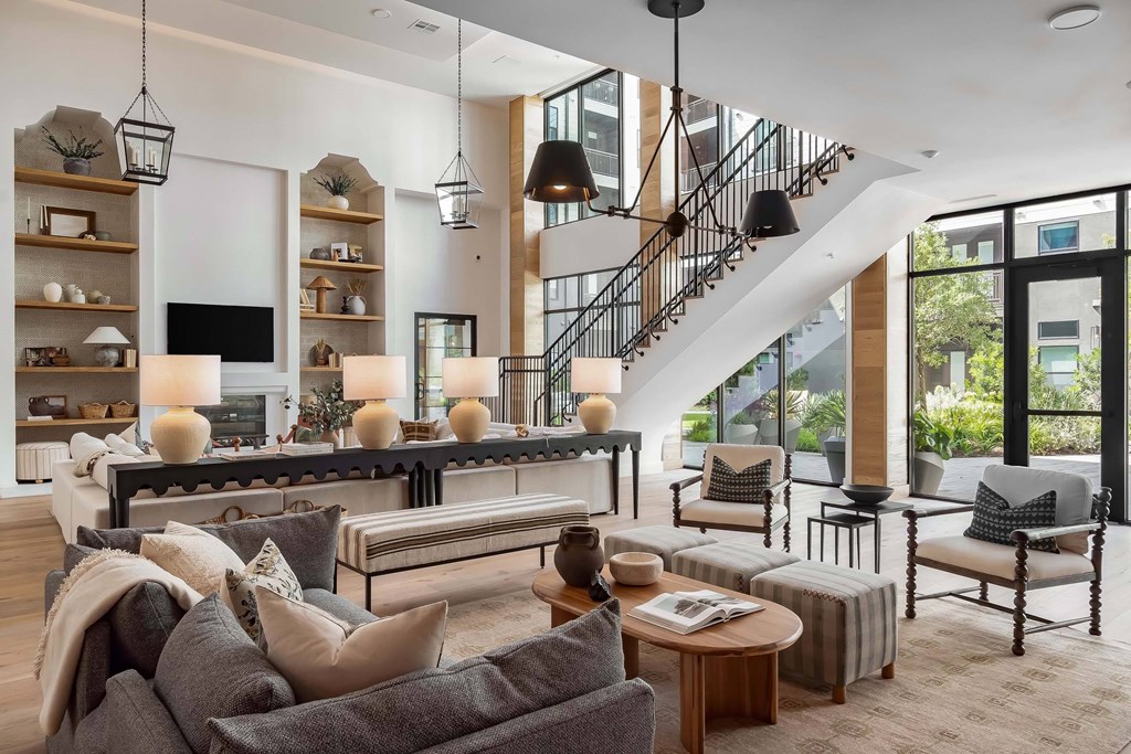 A modern living room with a staircase and a fireplace.