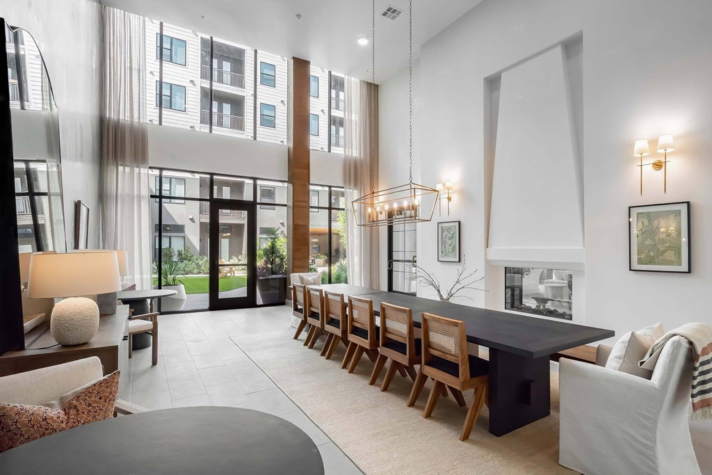 A modern dining room with a long table and chairs.