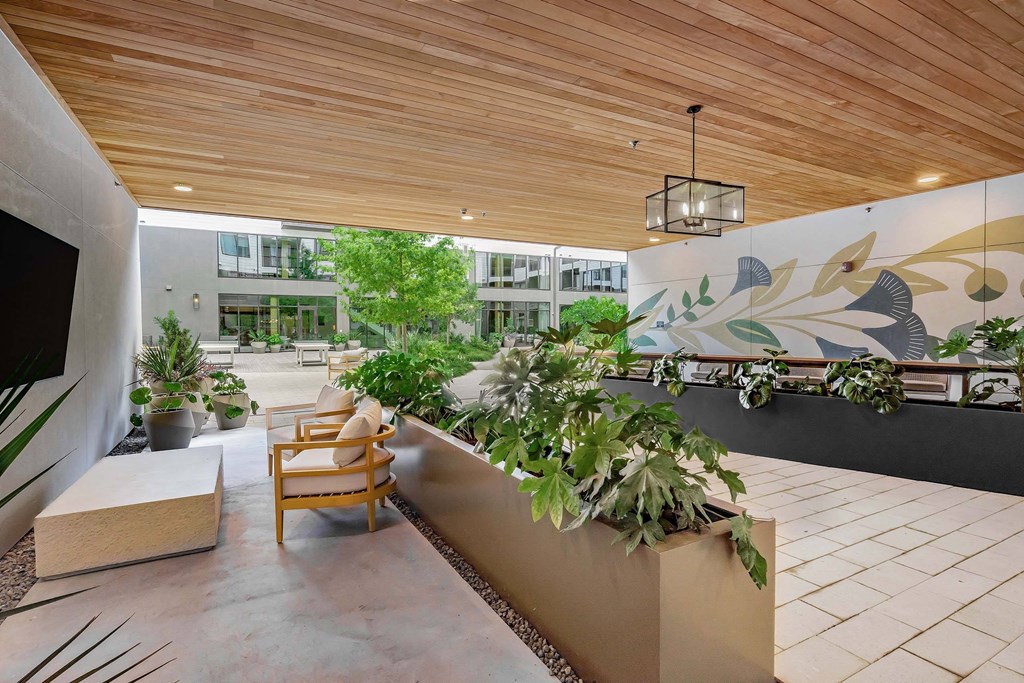 A wooden chair is placed on a patio with a wall mural.