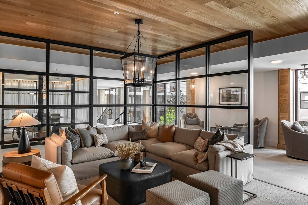 A modern living room with a wooden ceiling and a large sectional sofa.