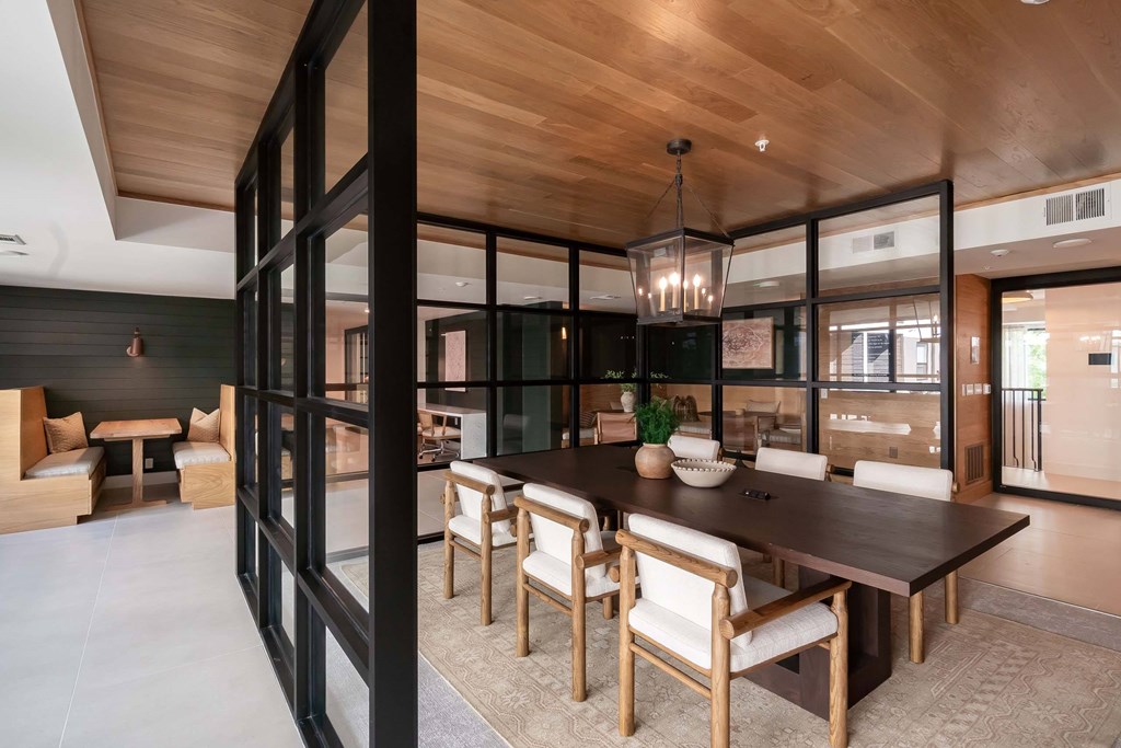 A modern dining room with a wooden table and chairs.