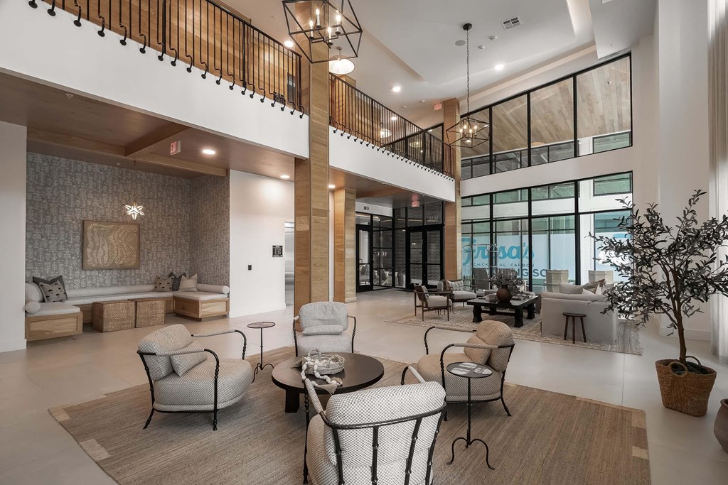 A spacious living room with a high ceiling and a balcony.