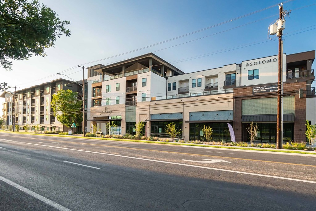 A street view of a building with the sign "ASOLOMO" on the right side.