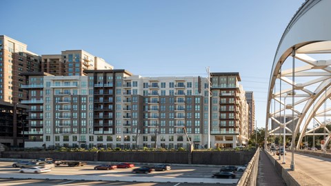A large building with many windows is situated next to a busy street.