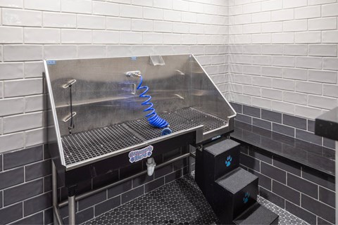 A stainless steel sink in a tiled bathroom.