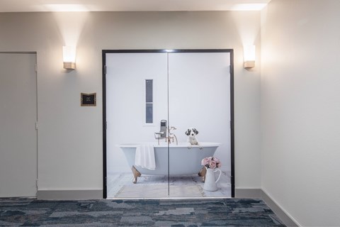 A bathroom with a white tub and a white towel.