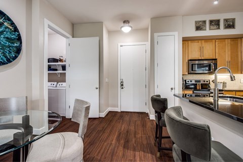 A kitchen with a dining table and chairs.