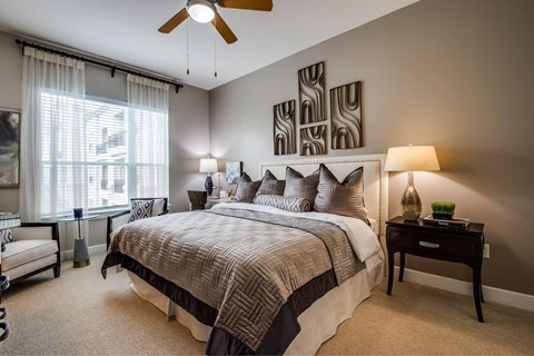 A bedroom with a large bed and a ceiling fan.